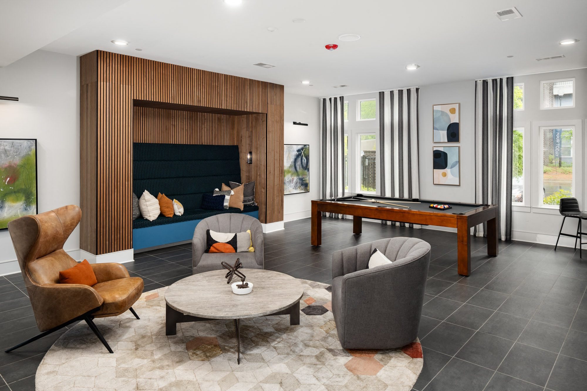 a living room with a pool table and chairs